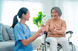 Nurse or doctor help to explain and give medicine to senior man during process of health support for home care.