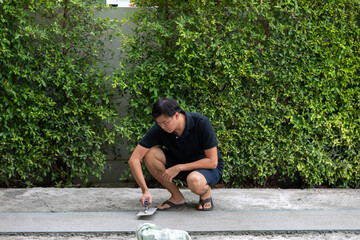 man working on explsed aggregate finish the front of the house