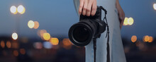 Professional Photographer With Modern Camera And Blurred View Of Beautiful City In Evening. Banner Design
