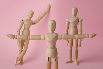 Wall Mural - Wooden human models in different poses on pink background