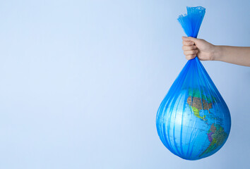 Woman holding plastic bag with globe and space for text on light background, closeup. Environmental conservation