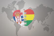 puzzle heart with the national flag of bolivia and serbia on a world map background.Concept.