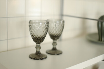 Two dark glass glasses on the shelf