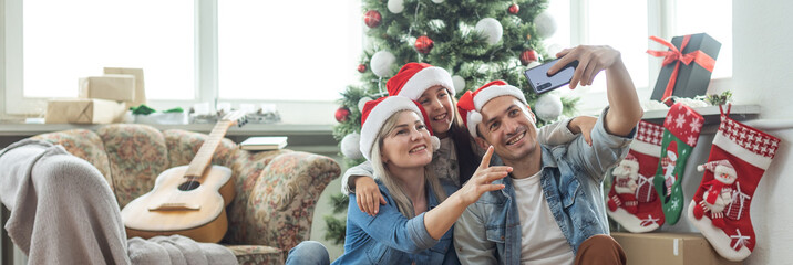 Wall Mural - family near the Christmas tree in their living room