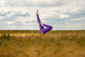 Legs in a field. woman doing a headstand in the middle of a field