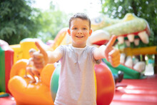 Happy Boy Having A Lots Of Fun On A Colorful Inflate Castle. Colorful Playground. Activity And Play Center For Kids