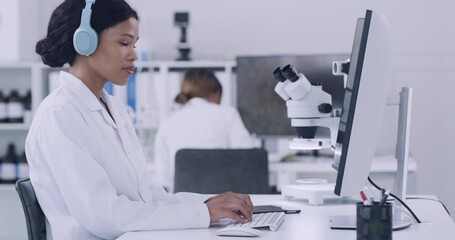 Poster - Scientist using a computer and listening to music on wireless headphones while working in laboratory. Focused pathologist and biochemical engineer using technology in a medical research facility