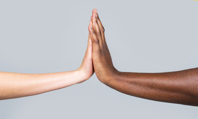 Wall Mural - White Woman, African man giving high five, Friendship Symbol.Mixed race couple holding hands. High-five gesture and tenderness of friendship between Black, White Woman and man success, teamwork
