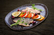 Sea bass fillet with vegetables ratatouille . On dark background, isolated.