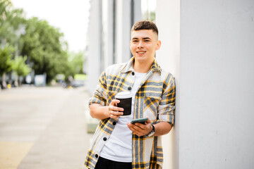 Wall Mural - Portrait of a young man with a phone on a city street