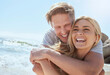 © Jade Maas/peopleimages.com - A young loving couple enjoying a day at the beach while smiling hugging and having fun, showing affection at the ocean. Romantic couple cuddling and laughing with joy while on summer vacation
