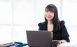 © David - Portrait of a smiling Asian Business woman using modern technology, working over the laptop.