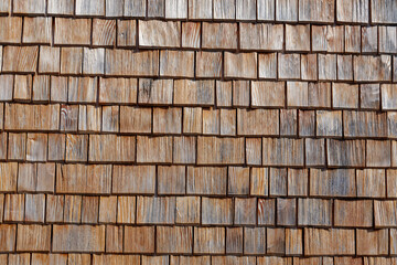 Facade cladding of wooden shingles on a house in the Austrian Alps. Copy space for your design. Web banner. 