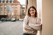 © contrastwerkstatt - Young woman standing in city looking at camera laughing