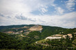 Quarry for extraction of minerals with equipment and machines, and road, in Rhodope Mountains covered with forests