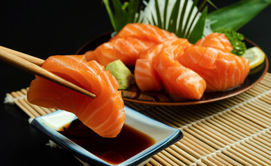 Sashimi, Salmon, Japanese food chopsticks and wasabi on the wood table.