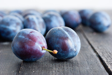 Canvas Print - plums on black wood table, front view