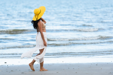 Young Asian happy woman walking on the beach on holiday.