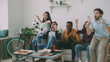 © silverkblack - Multi-ethnic group of friends sports fans with Brazilian flags watching football championship on TV together at home indoors and cheering up favourite team