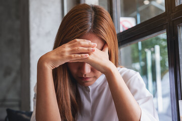 Wall Mural - A young woman with feeling sad and stressed, sick and headache