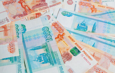 horizontal background of paper money spread out in a fan in denominations of one thousand and five thousand Russian rubles