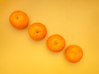 Top view of fresh oranges over a yellow background