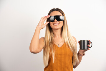 Wall Mural - Young woman posing with glasses and black cup