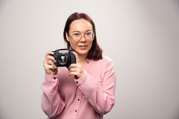 Wall Mural - Woman taking a picture with camera on white background