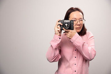 Wall Mural - Woman taking a picture with camera on white background