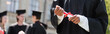 © LIGHTFIELD STUDIOS - Cropped view of african american bachelor holding diploma near blurred friends in park, banner.