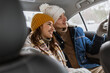 people, love and leisure concept - happy smiling couple hugging on car back seat in winter