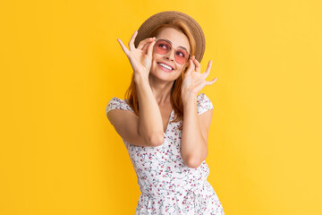 Wall Mural - happy woman in straw hat and sunglasses on yellow background