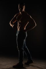 Wall Mural - Silhouette of topless guy posing and flexing in studio while twisting
