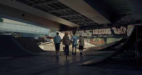 Teenage friends meeting together in urban skate park for leisure. Youth culture