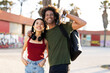 © JustLife - Beautiful couple having fun outdoors. Portrait of loving couple with skateboard...