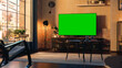 © Gorodenkoff - Stylish Loft Apartment Interior with TV Set with Green Screen Mock Up Display Standing on Television Stand. Empty Living Room at Home with Chroma Key Placeholder on Monitor. Zoom In Sunset Shot.