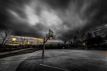 Breathtaking View Of A Basketball And Volleyball Courts Against Dark Cloudy Sky Background