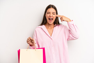 Wall Mural - pretty girl looking unhappy and stressed, suicide gesture making gun sign. shopping concept