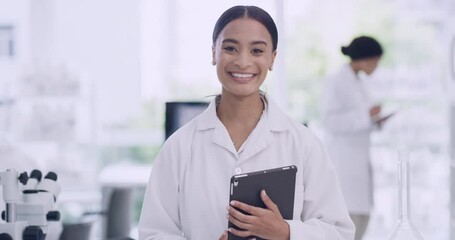 Leinwandbilder - Confident African biologist working on research using modern technology at medical science laboratory. Portrait of a young scientist using a digital tablet on blur background in a lab with coworkers