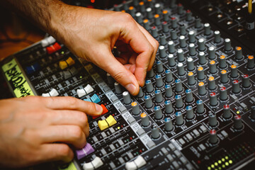 Wall Mural - Hands of the sound engineer on the music console.