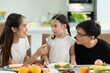 © Wosunan - Asian father and mother Show your love to little daughter and having breakfast together happily in the dining room of the house.
