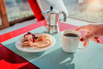 Wall Mural - cup of coffee and cake on the table sunny morning