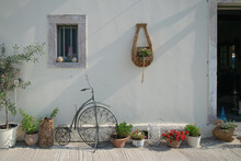 Old Bicycle And Other Decorations On White Wall Of House At Paxos In Greece