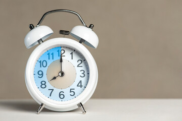 Fototapete - Eight o'clock on the alarm. A white alarm clock is on a white table. The clock hand points to 8 o'clock. Time to change to summer or winter time. Set an alarm for 8:00 or 20:00. copy space