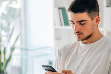 Canvas Print - young man with mobile phone chatting or playing games