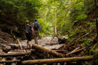 © Tasty Content  - Two friends are traveling through the mountains in the summer with backpacks. In the mountain forest.