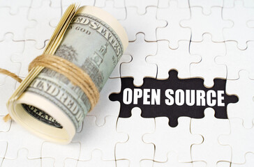 Aufkleber - Dollars lie on white puzzles, on a black surface there is an inscription - Open Source