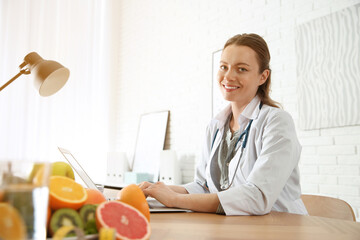 Poster - Nutritionist working with laptop at desk in office