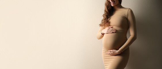 Wall Mural - Pregnant woman touching her belly on beige background, space for text. Banner design