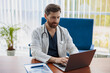 © Kostiantyn - Doctor therapist with stethoscope using laptop while working at medicine office